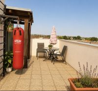 Die Terrasse einer 1-Zimmer-Wohnung mit Sitzgelegenheit und Boxsack in der Čerešňová-Straße in Chorvátsky Grob.