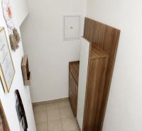 Treppe mit Stauraum in einer Einzimmerwohnung, weiße Wand, Holzdekor.