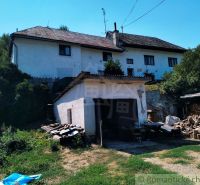 Ein Einfamilienhaus in Stará Turá mit Garage und geschnittenem Holz im Hof.