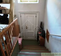 Treppe mit Schuhregal und weißen Türen in einem Einfamilienhaus.