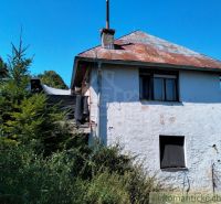 Ein Einfamilienhaus in Stará Turá mit einem abgenutzten Dach und überwucherter Umgebung.