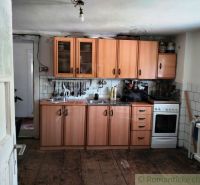 Eine Küche in einem Einfamilienhaus mit einem Boden in Holzoptik und Holzschränken.