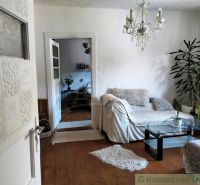 Wohnzimmer in einem Einfamilienhaus mit Sofa und Kronleuchter, Boden mit Holzdekor.