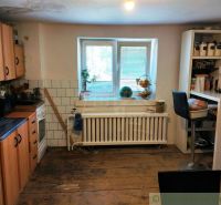 Küche in einem Einfamilienhaus mit Holzboden, ausgestattet mit Geräten und Möbeln.