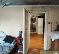 Innenraum eines Einfamilienhauses mit Bett und Blick auf die Küche durch offene Türen.
