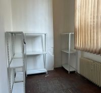 Ein Büro mit Regalen, einem Heizkörper und Vorhängen, ein Boden mit Holzdekor.