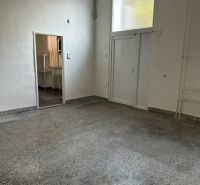 Innenraum eines Büros mit weißen Wänden und einem Boden in Betonoptik.