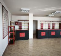 Gewerbeflächen mit Theke und Regalen, Boden mit Holzdekor, in Schwarz-Rot.