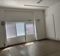 Innenraum von Geschäftsräumen mit großen Fenstern und Fliesenboden.