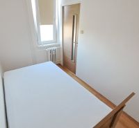 Schlafzimmer mit weißen Wänden und einem Boden in Holzoptik in einer 2-Zimmer-Wohnung.
