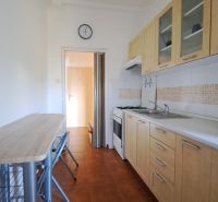 Küche in einer 2-Zimmer-Wohnung mit Esstisch und Geräten.
