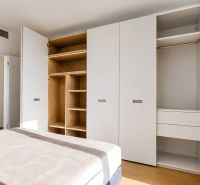 Weißer Einbauschrank mit Schubladen und offenen Regalen in einer 3-Zimmer-Wohnung, Boden mit Holzdekor.