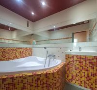 Badezimmer mit einer mit bunten Mosaikfliesen verkleideten Badewanne in einer 3-Zimmer-Wohnung.