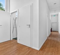 Innenraum von Geschäftsräumen mit weißen Wänden, Holzboden und Kleiderschrank.