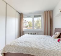 Schlafzimmer in einer 3-Zimmer-Wohnung mit einem großen Bett und einem Einbauschrank.