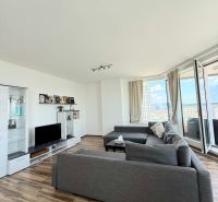 Wohnzimmer mit Holzboden, Sofa und Fernseher in einer 3-Zimmer-Wohnung.
