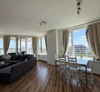 Wohnzimmer in einer 3-Zimmer-Wohnung mit Holzboden und großen Fenstern.