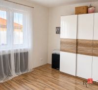 Weißer Schrank mit Holzdekor und Vorhängen im Zimmer eines Einfamilienhauses.
