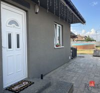 Das Einfamilienhaus in der SNP-Straße in Čaňa hat eine graue Fassade und einen gepflegten Garten mit Pool.
