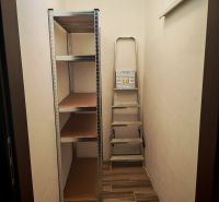 Stauraum in einer 2-Zimmer-Wohnung mit Regalsystem und Leiter.
