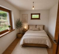 Schlafzimmer in einem Einfamilienhaus mit Bett, Wandzeichnung und Boden in Holzoptik.