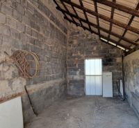 Ein Schuppen mit einem schrägen Blechdach und Betonwänden, der sich in einem Einfamilienhaus befindet.