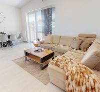 Wohnzimmer in einer 3-Zimmer-Wohnung mit einem beigen Sofa und einem Esstisch.