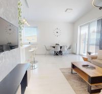 Wohnzimmer in einer 3-Zimmer-Wohnung mit Holzboden, Sofa und Esstisch.