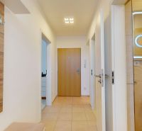 Flur mit Eingang zum Badezimmer und Spiegel in einer 3-Zimmer-Wohnung mit gefliestem Boden.