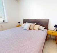 Schlafzimmer mit großem Bett, Nachttischen und dekorativen Kissen in einer 3-Zimmer-Wohnung.