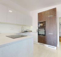 Küche in einer 3-Zimmer-Wohnung mit weißen Schränken und einem Boden in Holzoptik.