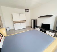 Ein Zimmer mit Fernseher und Schrank, 1-Zimmer-Wohnung, Boden mit Holzdekor.