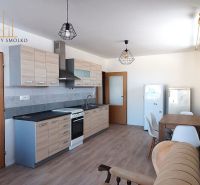 Küche in einer 2-Zimmer-Wohnung mit Holzboden und Esstisch.
