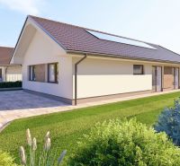 Ein Einfamilienhaus in Tuchyňa mit einem Schrägdach und einem Parkplatz vor dem Gebäude.