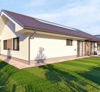 Ein Einfamilienhaus in Tuchyňa, umgeben von einem grünen Rasen und einer Gartenterrasse.
