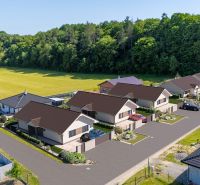 Einfamilienhäuser in der Straße Tuchyňa im Dorf Tuchyňa, umgeben von Wald und Feld.