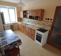 Küche in einer 2-Zimmer-Wohnung mit Esstisch, Küchenzeile und Geräten.