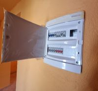 Ein elektrischer Verteilerkasten mit offenen Türen im Inneren eines Einfamilienhauses.