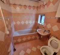 Badezimmer mit Fliesen und Verkleidung, Badewanne, Waschbecken und Toilette im Einfamilienhaus.