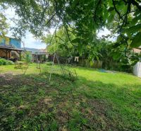 Der Garten beim Einfamilienhaus in der Šípošova-Straße in Šahy mit Schaukel und Bäumen.