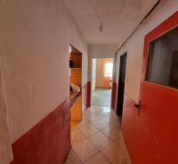 Der Flur in einem Einfamilienhaus mit gefliestem Boden und roten Türen.