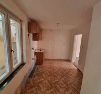 Küche im Einfamilienhaus mit Fenster und Boden in Holzoptik.