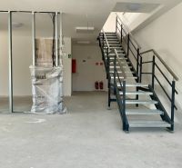 Innenraum mit Treppe in Lagern und Hallen mit Metallgeländer und Tragbalken.