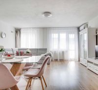 Helles Wohnzimmer in einer 2-Zimmer-Wohnung mit Holzboden, stilvollen Möbeln und Dekorationen.