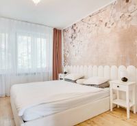 Schlafzimmer in einer 2-Zimmer-Wohnung mit Holzboden und dezenter Tapete.