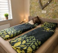 Schlafzimmer in einer 3-Zimmer-Wohnung mit einem Bett und einem dekorativen Herz an der Wand.