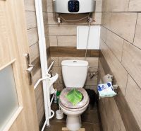 Badezimmer in einer 3-Zimmer-Wohnung mit Holzboden und einem hängenden Boiler.