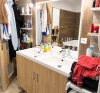 Badezimmer in einer 3-Zimmer-Wohnung mit Holzboden und Doppelwaschbecken.