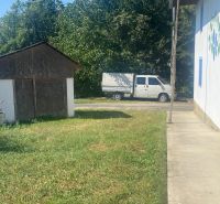 Ein Einfamilienhaus in Brestovec an der Straße mit Rasen, Unterstand und einem Lieferwagen im Hintergrund.