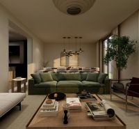 Wohnzimmer in einem Einfamilienhaus mit einem bequemen grünen Sofa, einem Tisch und Kerzenhaltern.